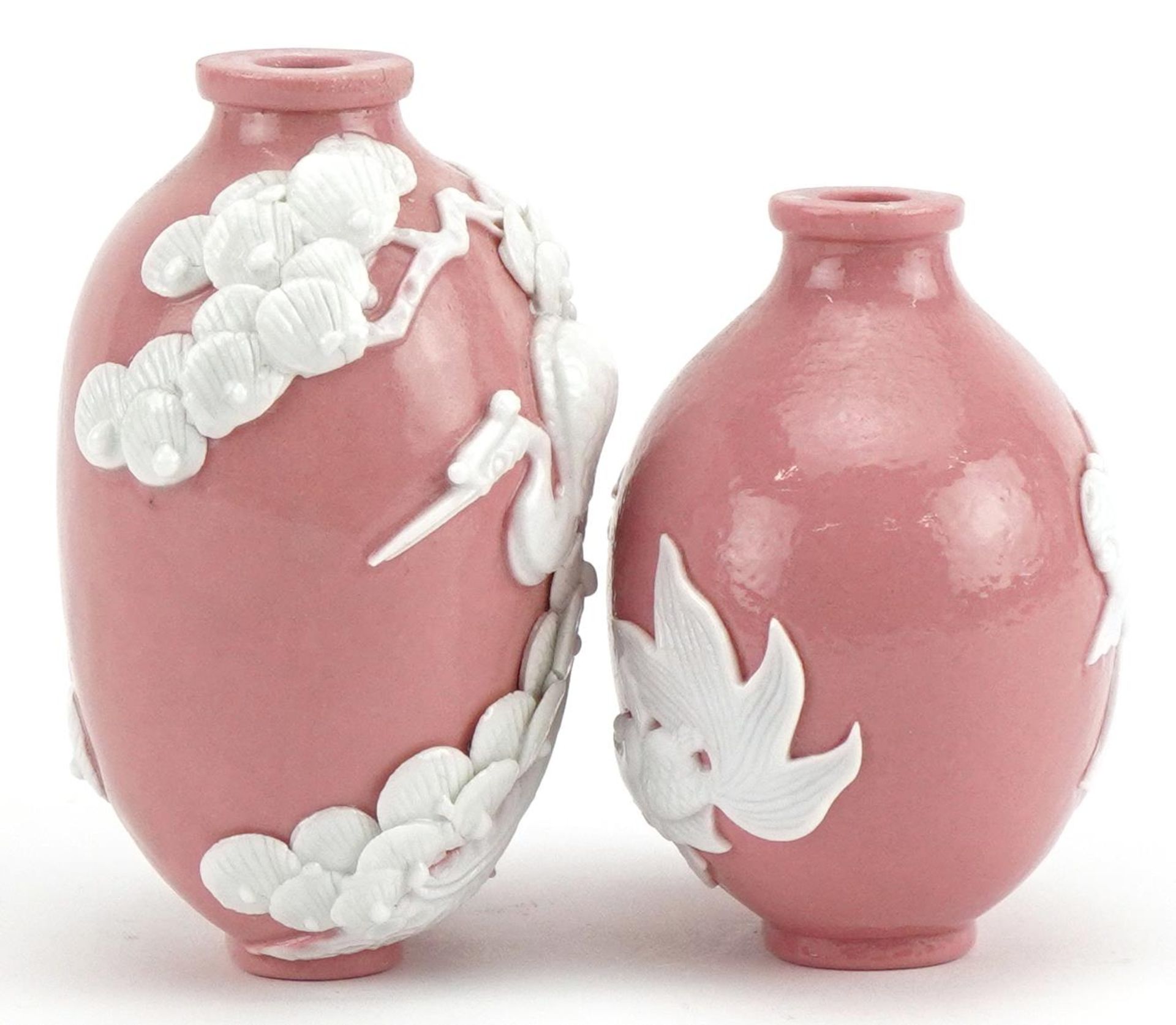 Two Chinese porcelain pink ground snuff bottles decorated in relief with fish and a crane, the - Bild 4 aus 8
