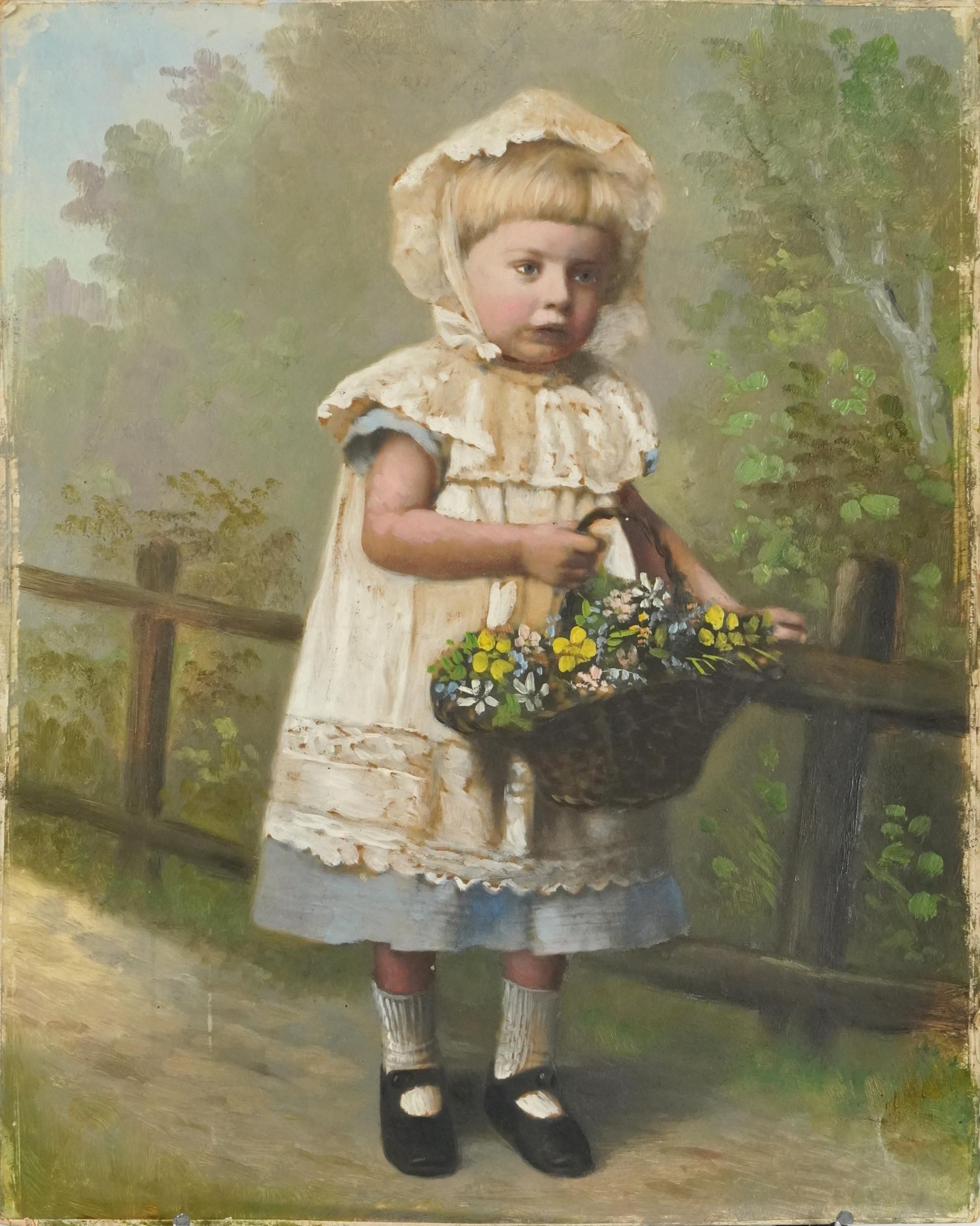 Portrait of a young girl wearing a white bonnet holding a basket of flowers beside a fence,