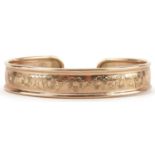 9ct gold floral engraved cuff bangle, 6.5cm wide, 9.0g