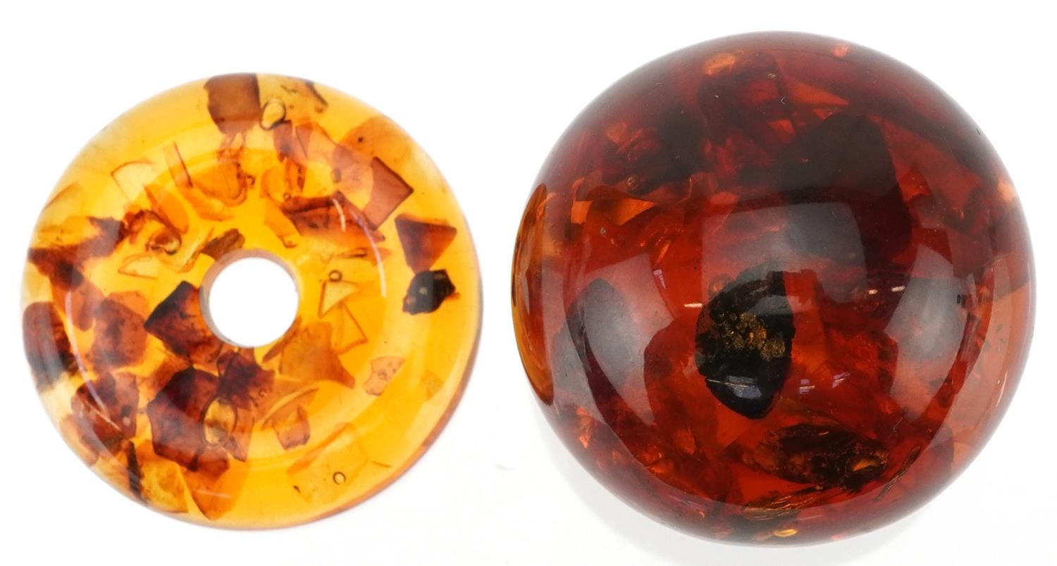 Polished natural amber sphere on stand with encased insects, 6cm high, 91.5g