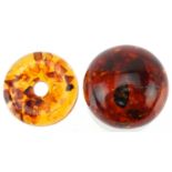 Polished natural amber sphere on stand with encased insects, 6cm high, 91.5g