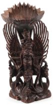 Large Burmese hardwood carving of a deity and mythical animals, 56cm high