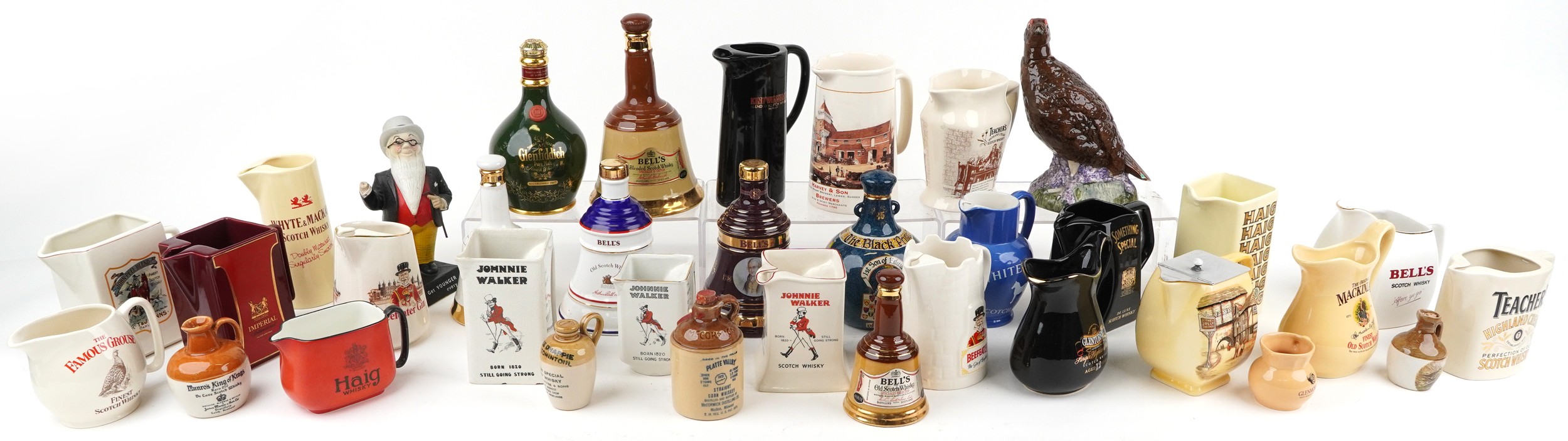 Collection of breweriana interest advertising pub jugs and flagons and an advertising figure
