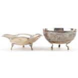 Two circular silver three footed dishes, one engraved with flowers and foliage, the largest 13.5cm