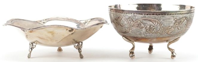 Two circular silver three footed dishes, one engraved with flowers and foliage, the largest 13.5cm