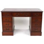 Mahogany twin pedestal desk with red tooled leather insert fitted with an arrangement of nine