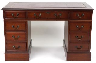 Mahogany twin pedestal desk with red tooled leather insert fitted with an arrangement of nine