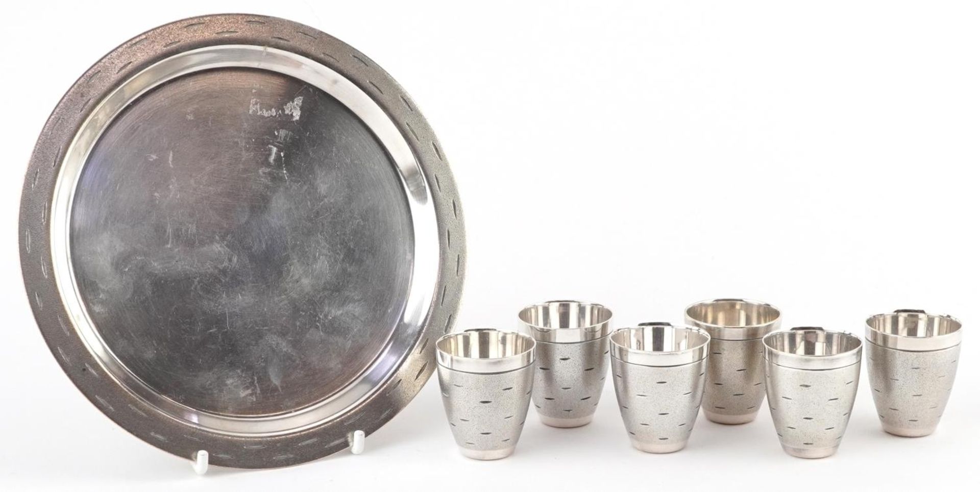 Set of six Modernist chrome shot glasses on circular tray, largest 16cm in diameter