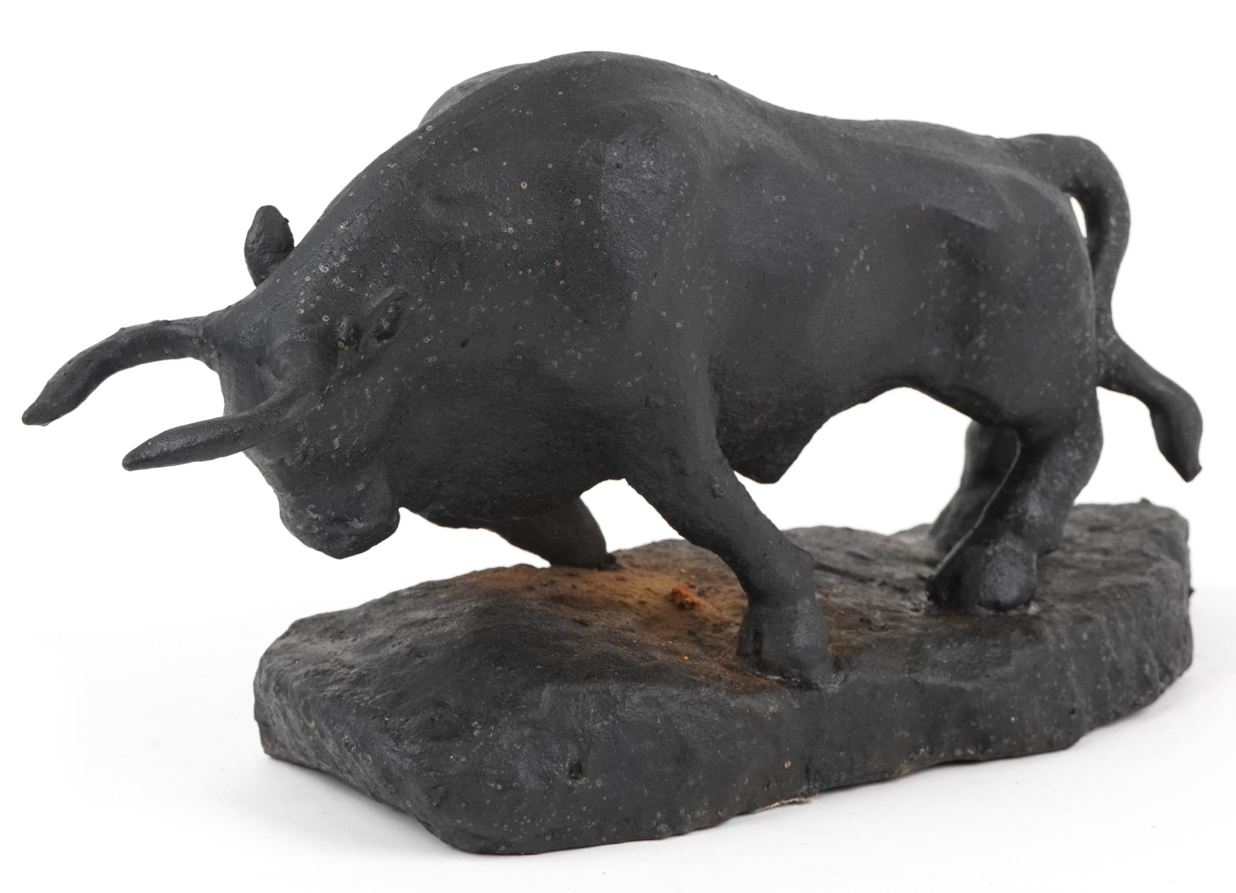 Black painted cast iron sculpture of a raging bull, 30.5cm in length