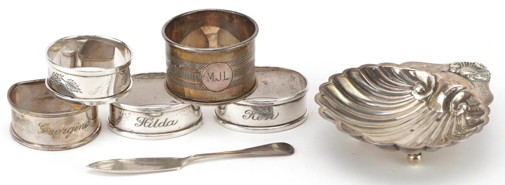 Edwardian and later silver objects comprising five napkin rings, butter knife and shell shaped