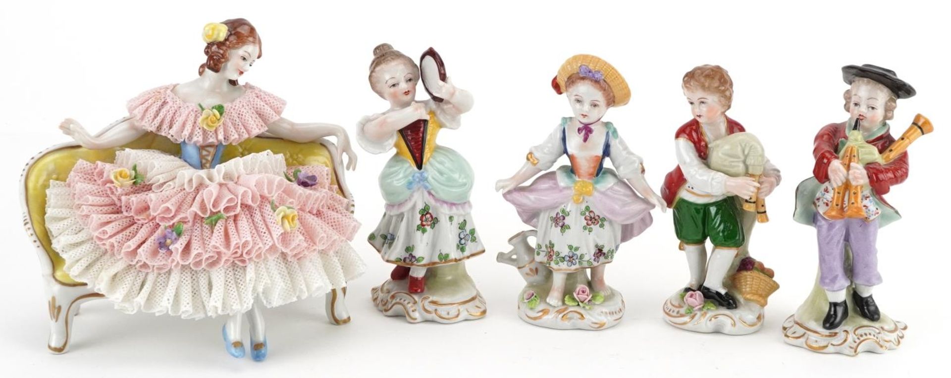 German porcelain comprising four Dresden figurines and a lace figurine in the form of a female on
