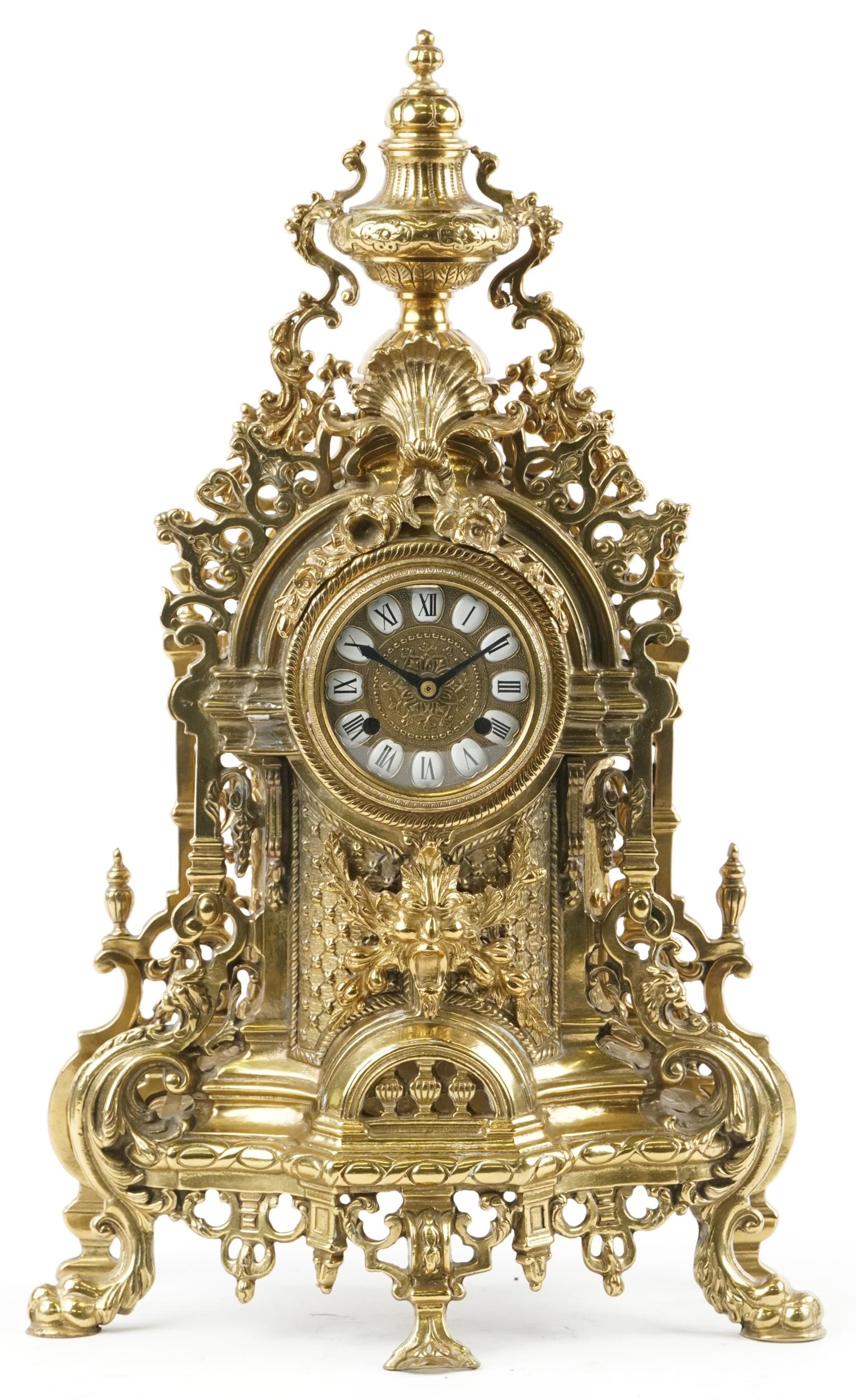 Large 19th century style classical brass mantle clock with urn finial and mask having circular