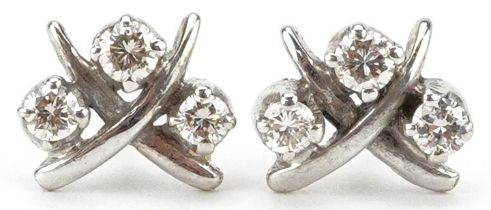 Pair of unmarked gold diamond three stone stud earrings, the largest diamonds each approximately 2.