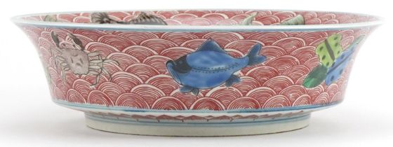 Chinese porcelain bowl hand painted in the famille verte palette with fish amongst crashing waves,