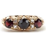 9ct gold garnet and white spinel seven stone ring with ornate pierced setting, size J, 2.5g