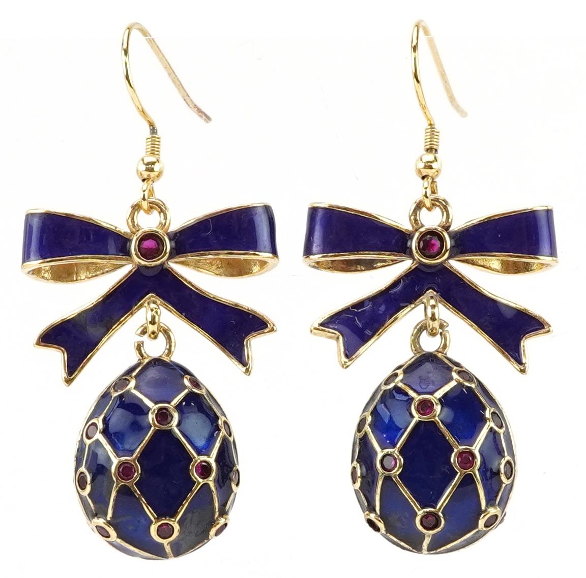 Pair of silver gilt blue enamel and garnet drop earrings in the form of bows with eggs, each set