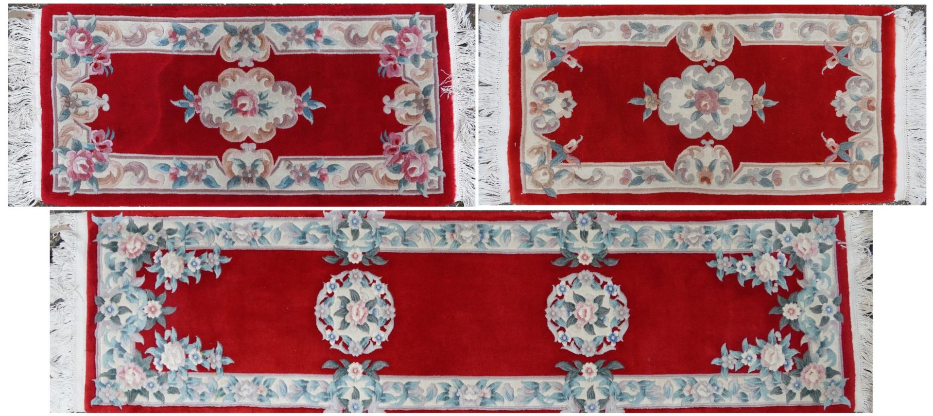 Three Chinese red ground floral rugs including a runner, the largest 255cm x 70cm