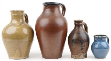 Three studio pottery jugs and a flagon including a blue glazed example by Winchcombe, the largest