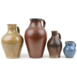 Three studio pottery jugs and a flagon including a blue glazed example by Winchcombe, the largest