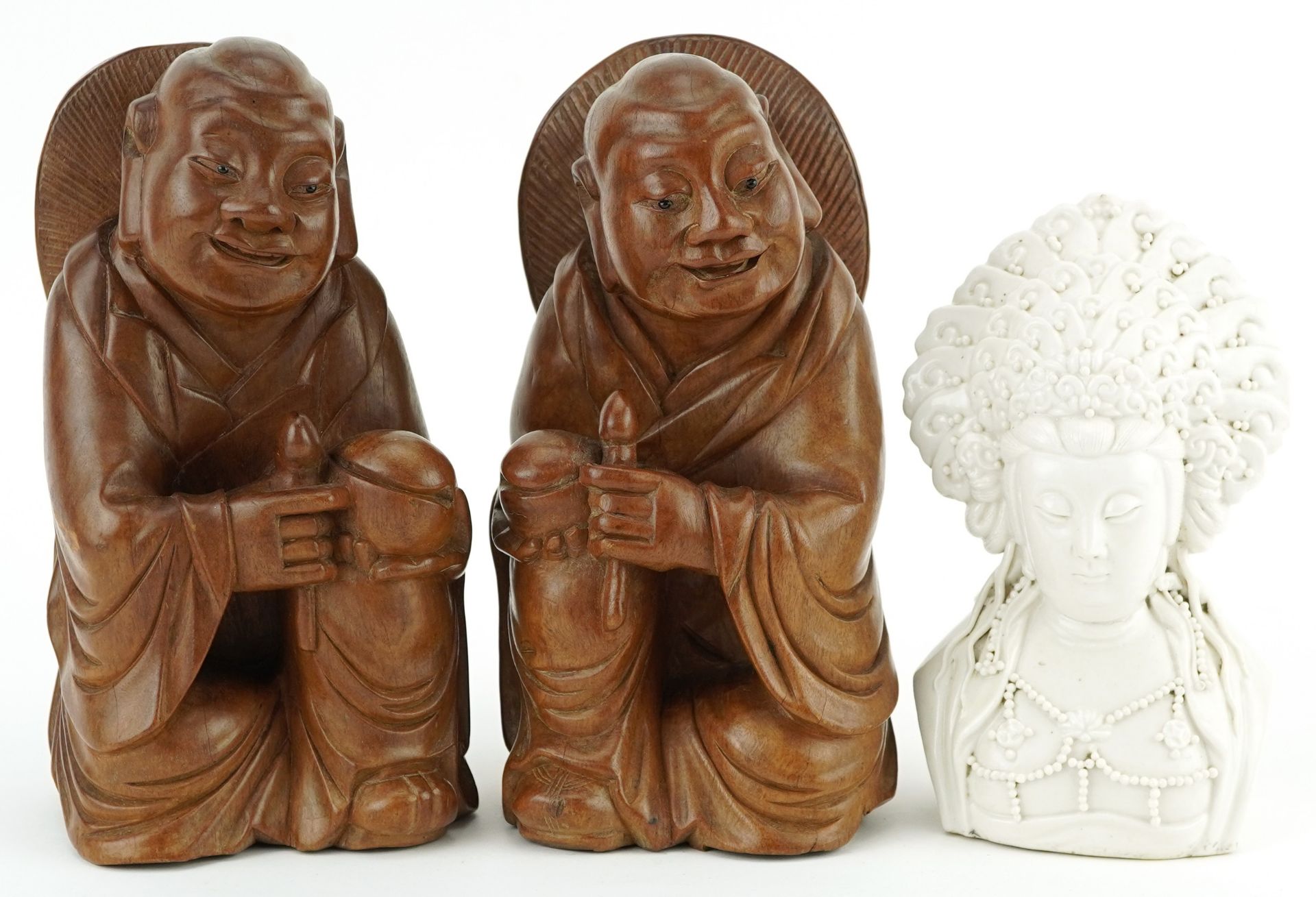 Pair of Chinese hardwood carvings of Buddha and blanc de chine glazed porcelain bust of Guanyin, the