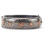 Victorian style silver and gold floral engraved hinged bangle housed in a W Hinds Brighton jewellers