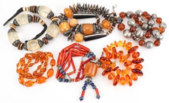 Six Asian necklaces including natural amber, amber coloured facetted beads and coral