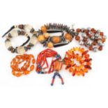 Six Asian necklaces including natural amber, amber coloured facetted beads and coral