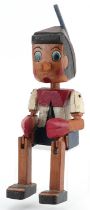 Hand painted carved wood figure of Pinocchio with jointed arms and legs, 35cm high