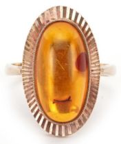 Modernist 9ct gold cabochon natural amber ring with engine turned setting, size P, 4.8g
