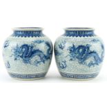 Pair of Chinese blue and white porcelain jar vases hand painted with dragons chasing the flaming
