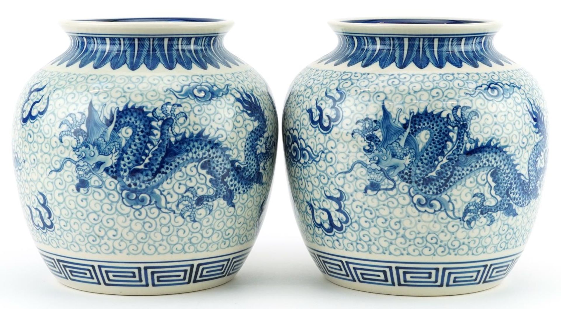 Pair of Chinese blue and white porcelain jar vases hand painted with dragons chasing the flaming