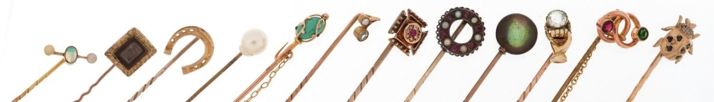 Twelve antique and later gold and yellow metal stickpins including ruby and diamond, opal and