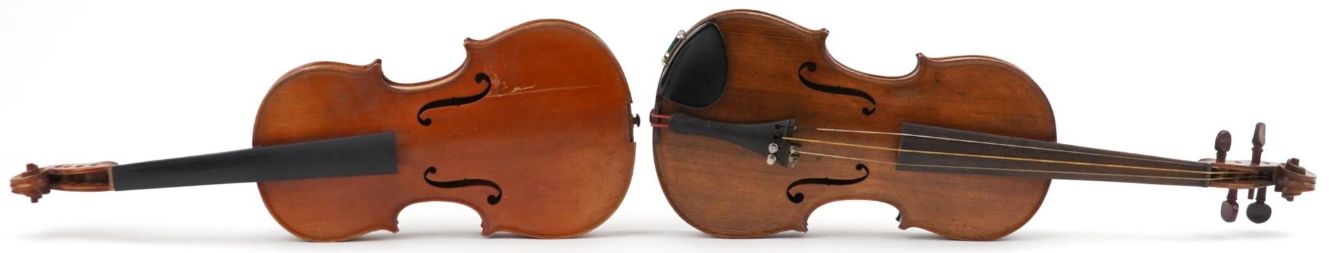 Two wooden violins with green baize lined wooden cases, the violin back 14 inches in length