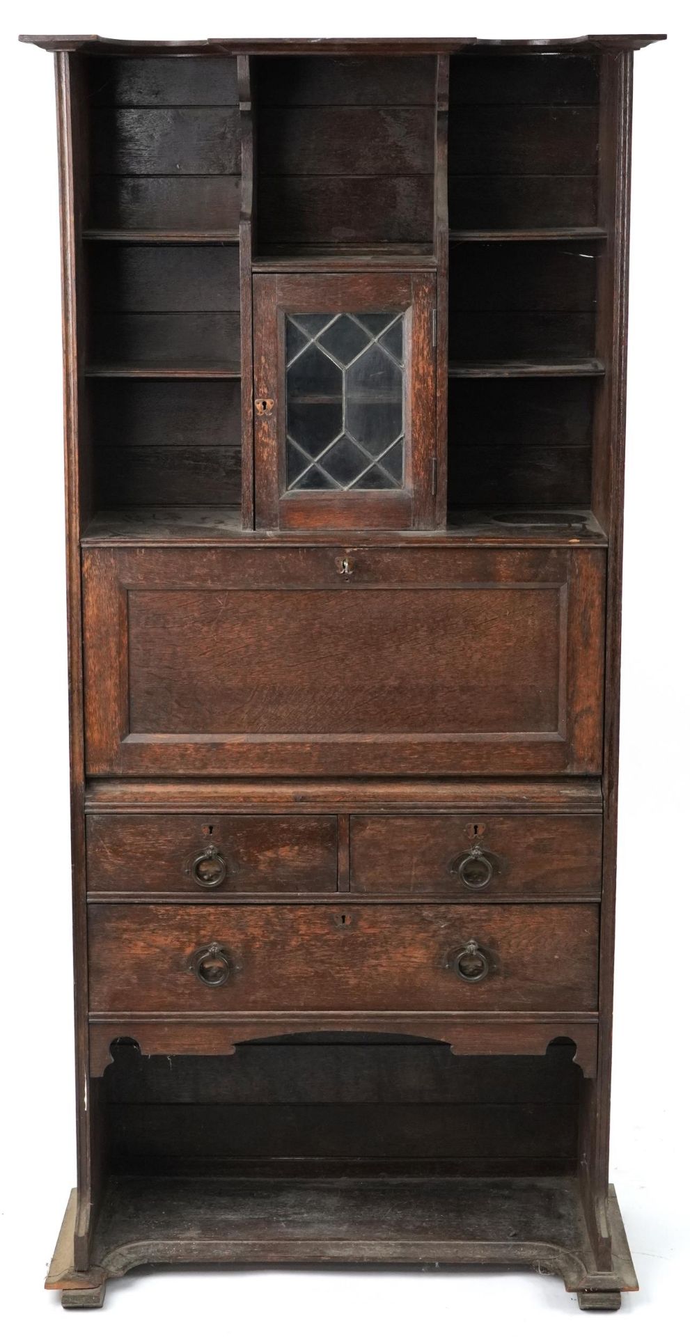 Arts & Crafts oak student's bureau fitted with leaded glass door above a fall and arrangement of