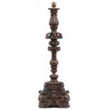 Large antique oak candle holder profusely carved with foliage, overall 76cm high