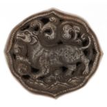 Indo Persian white metal buckle cast and pierced with a mythical animal amongst clouds, 8.5cm wide