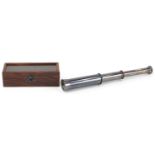 Three draw brass telescope housed in a glazed hardwood case, the telescope 14cm in length when