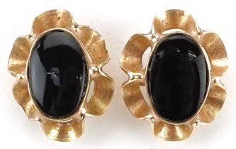 Pair of 9ct gold black onyx flower head stud earrings, each 9mm high, total 0.7g