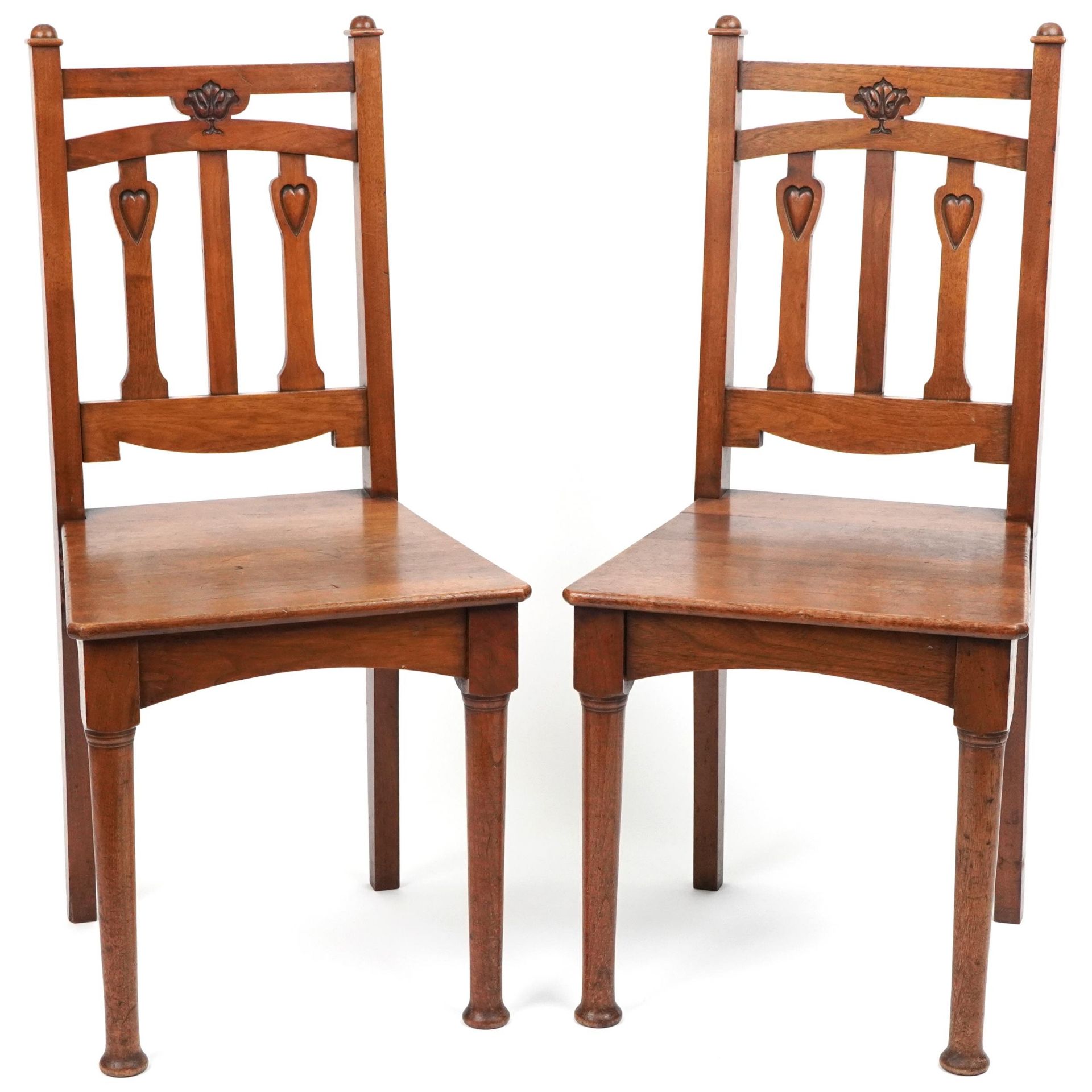 Pair of Arts & Crafts oak side chairs carved with hearts, 96cm high