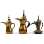 Three Omani brass dallah coffee pots including an example with bird knops, the two others with