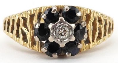 18ct gold diamond and sapphire flower head ring with pierced bark design shoulders, size M, 4.2g