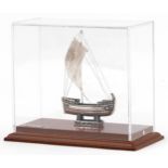 950 grade silver model of The Ship of Kyrenia housed in a display case, overall 14.5cm high,