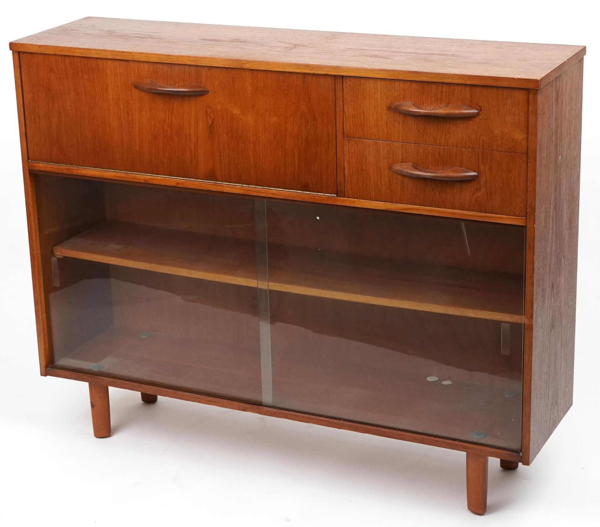 Avalon, mid century teak side cabinet fitted with a fall and two drawers above a pair of glass