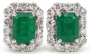 Pair of 18ct white gold emerald and diamond cluster stud earrings, total emerald weight
