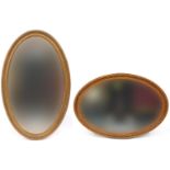Two oval gilt framed wall mirrors with bevelled glass, the largest 93cm x 58cm