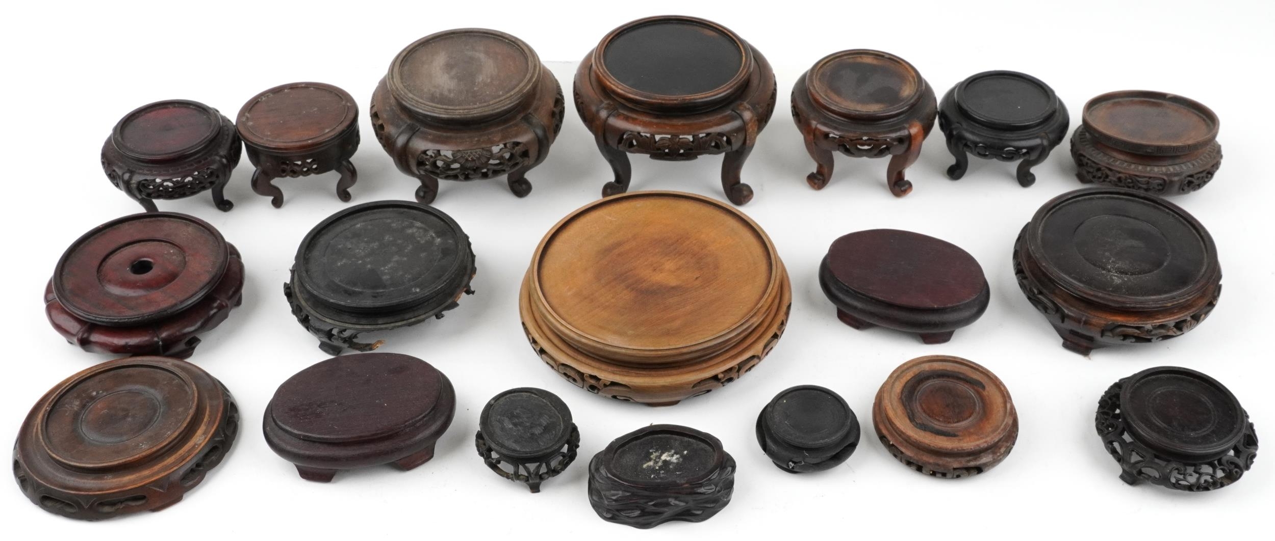 Antique and later Chinese carved hardwood stands, some possibly Hongmu, the largest 19cm in diameter