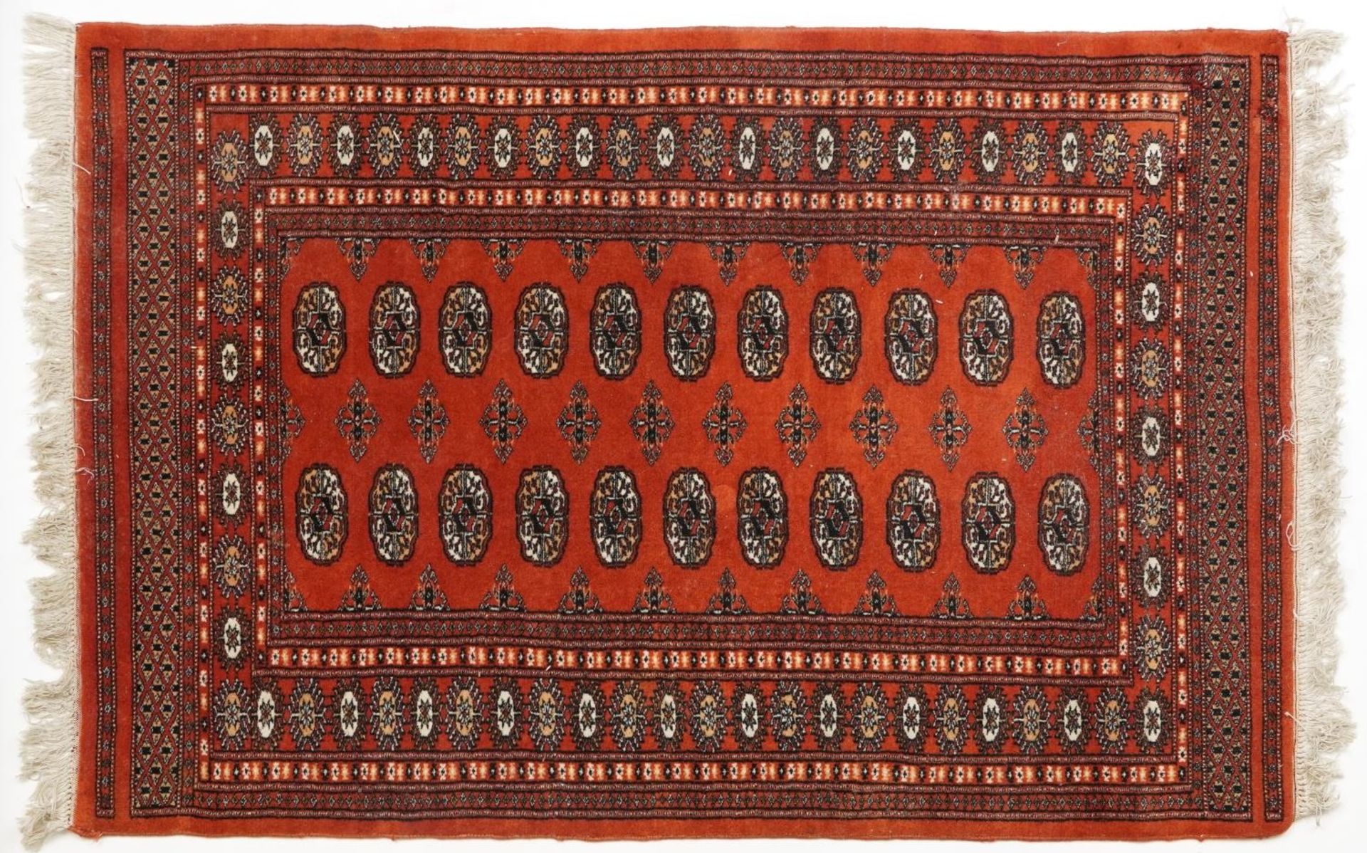 Rectangular Turkish Bokhara peach ground rug having an allover repeat flower head design, 150cm x