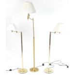 Three contemporary adjustable brass standard lamps with cream shades including a pleated example