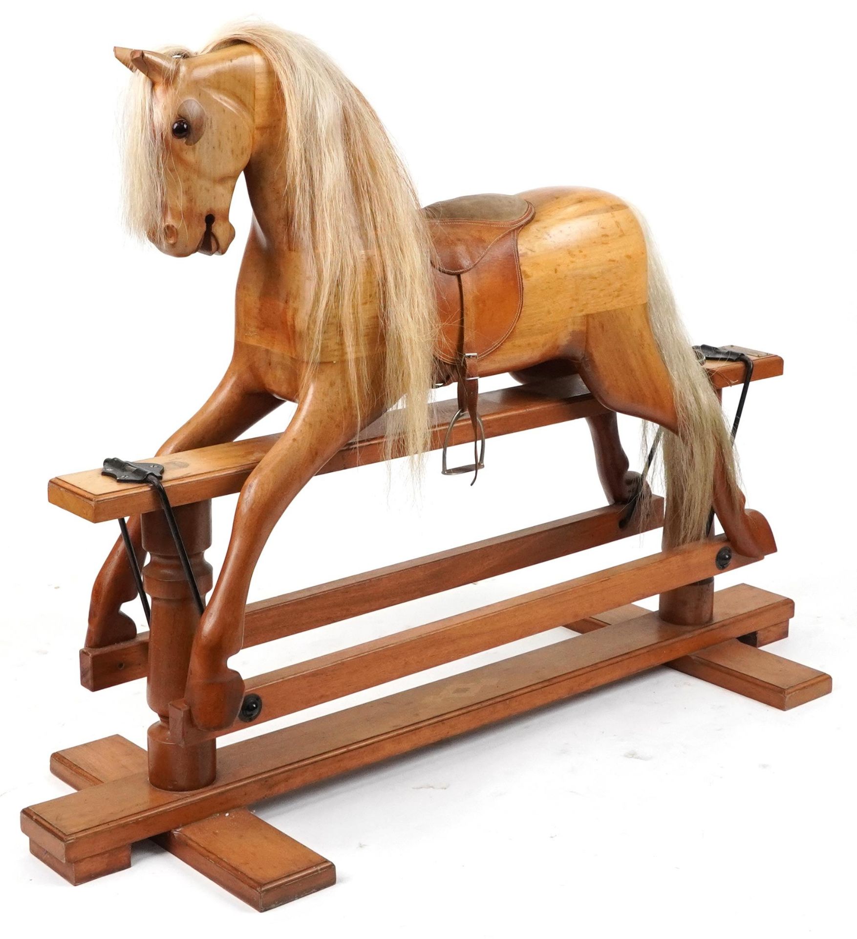 Large carved hardwood rocking horse with leather saddle on hardwood stand having brass plaque