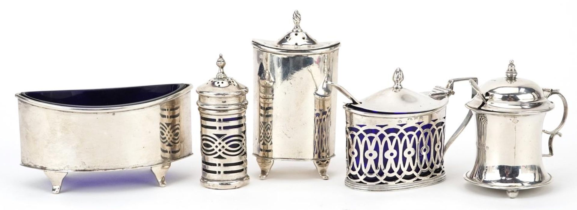 Five Art Deco and later silver cruet items, four with blue glass liners, the largest 9cm wide,